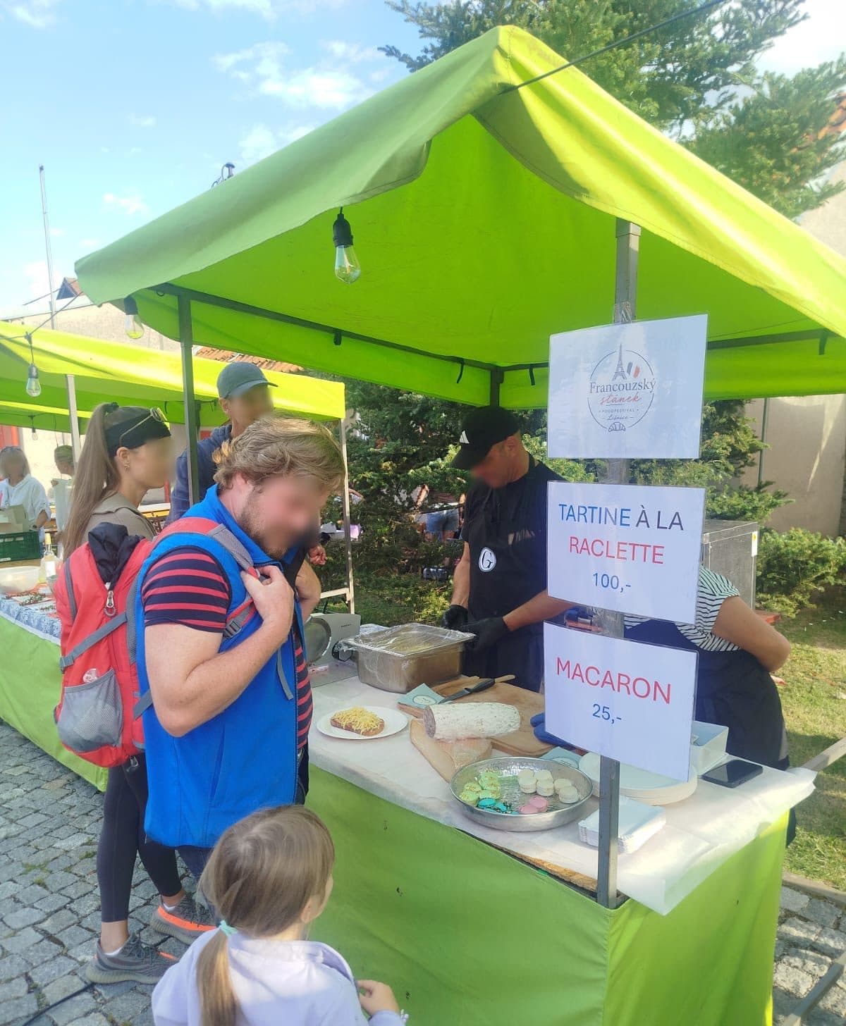 Francouzský stánek s raclette a macarony — jedna z mnoha kuchyní na návsi